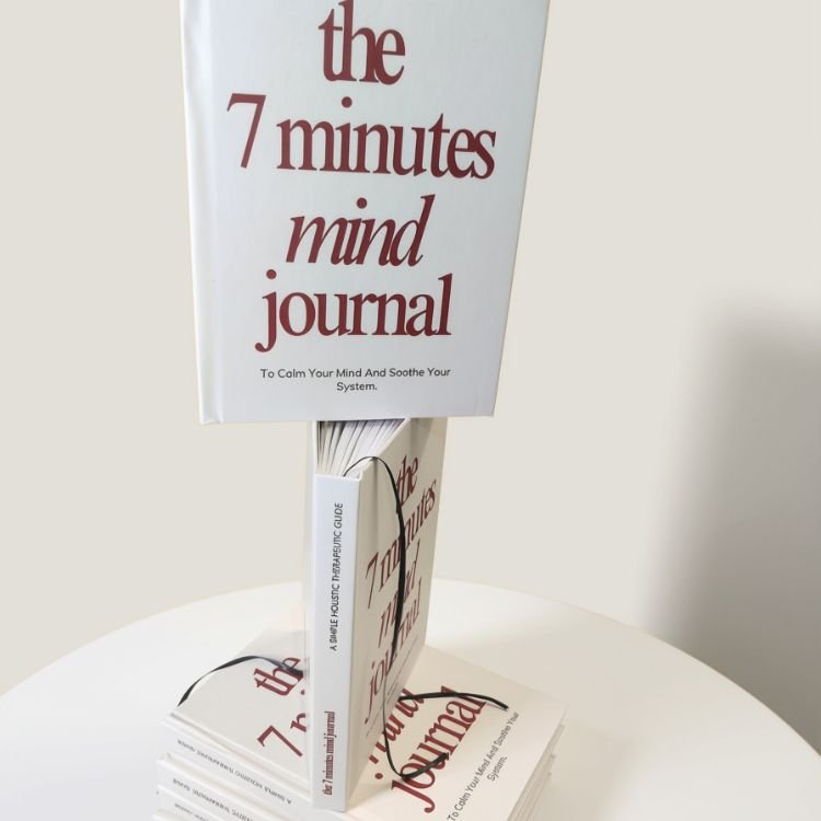The 7-Minute Mind Journal hardcover by Anaita Arthur Veigas, standing upright on a stack of journals